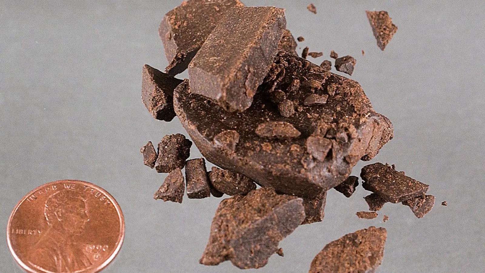 Pieces of hashish beside a coin for scale. Illustrative photo