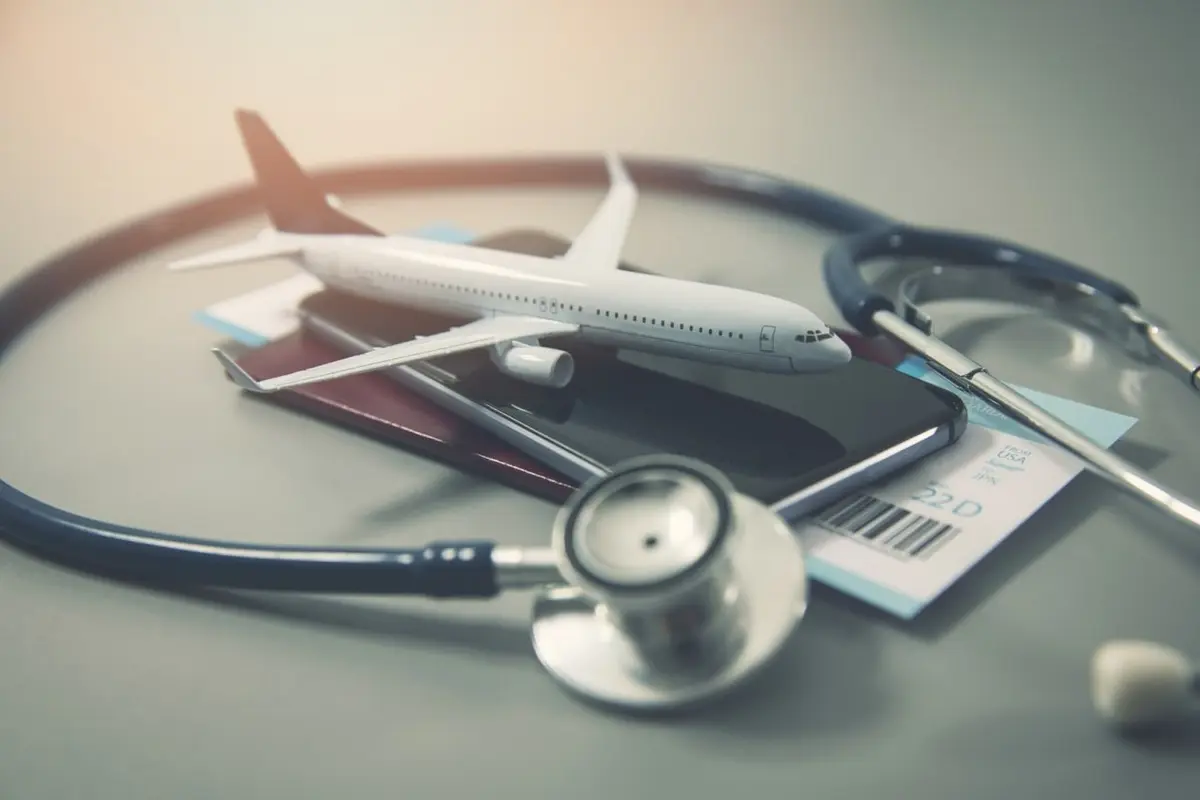 Medical tourism illustration showing a model aircraft, stethoscope and travel documents