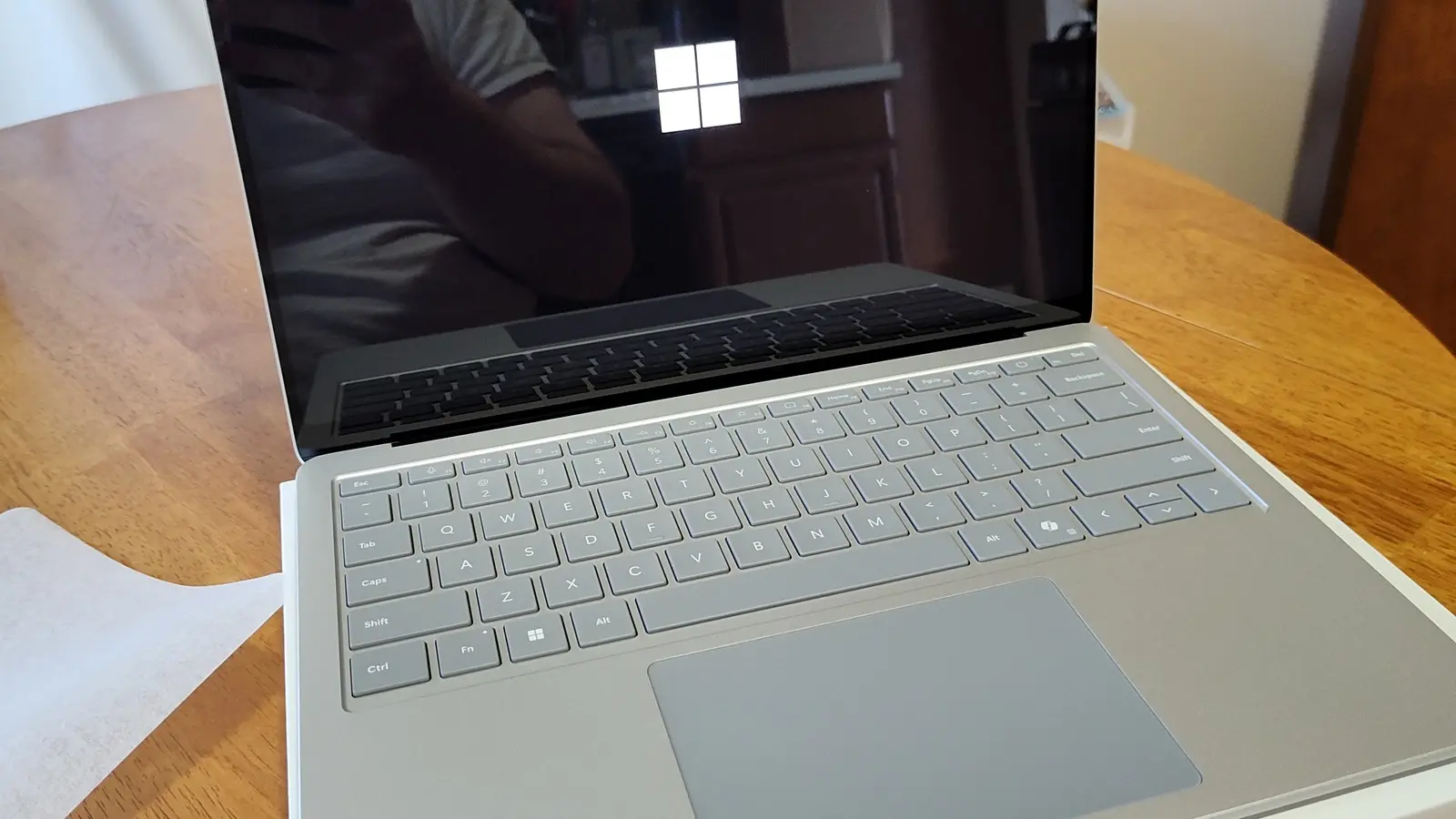 A modern Microsoft Surface Laptop 7 showing the Windows logo on its screen