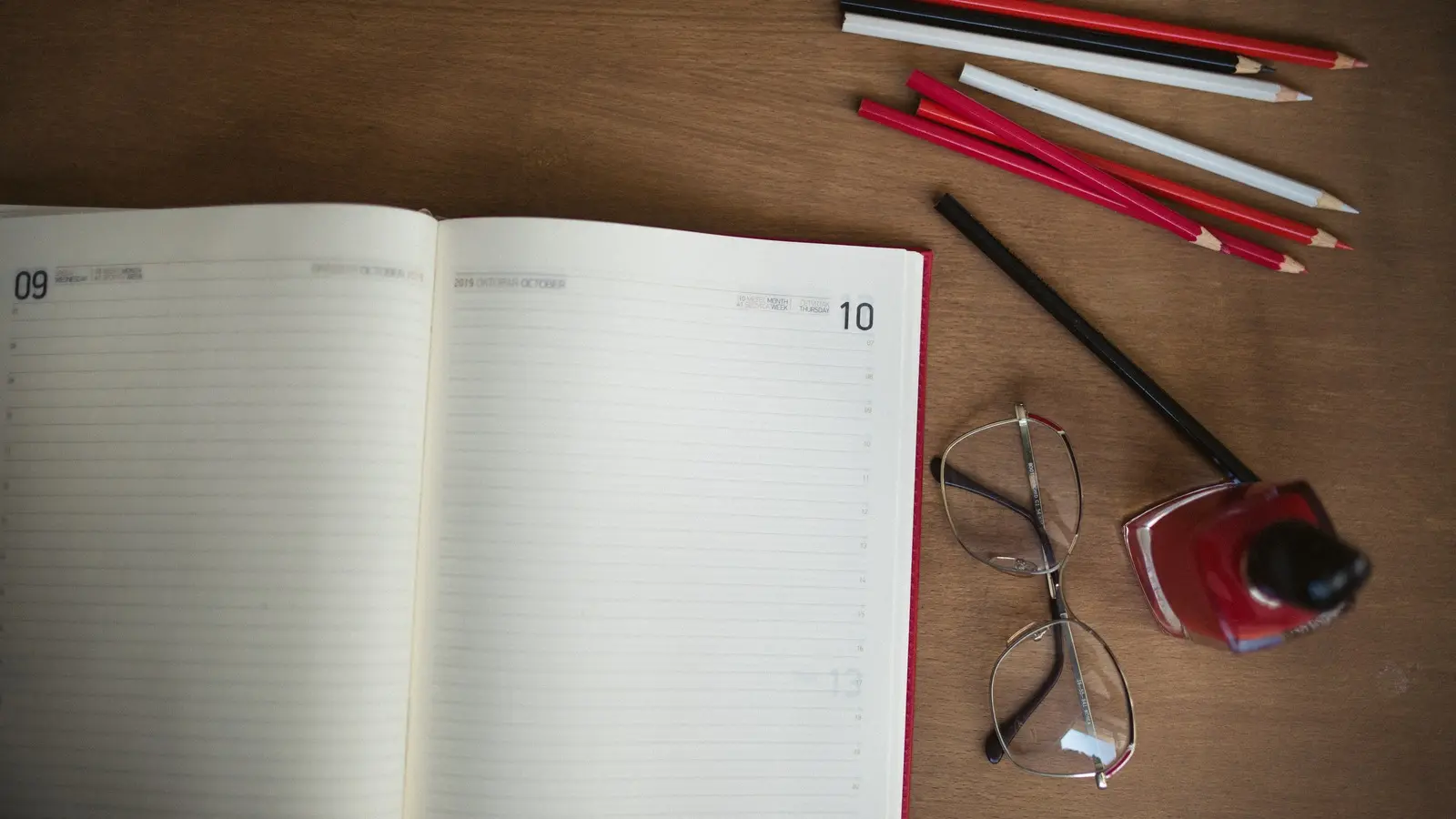 School supplies and an open notebook on a wooden desk