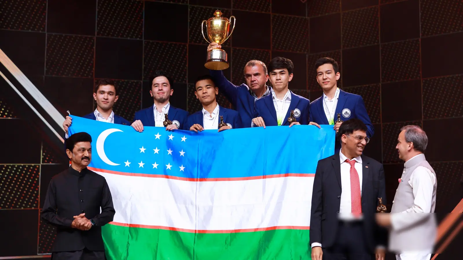 Uzbekistan’s chess team holding the 2022 Olympiad trophy